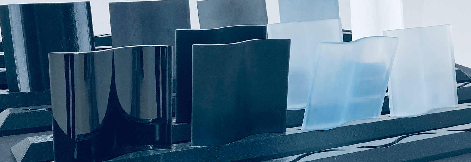 Verschiedene SLA-gedruckte Musterbauteile in schwarz und transparent